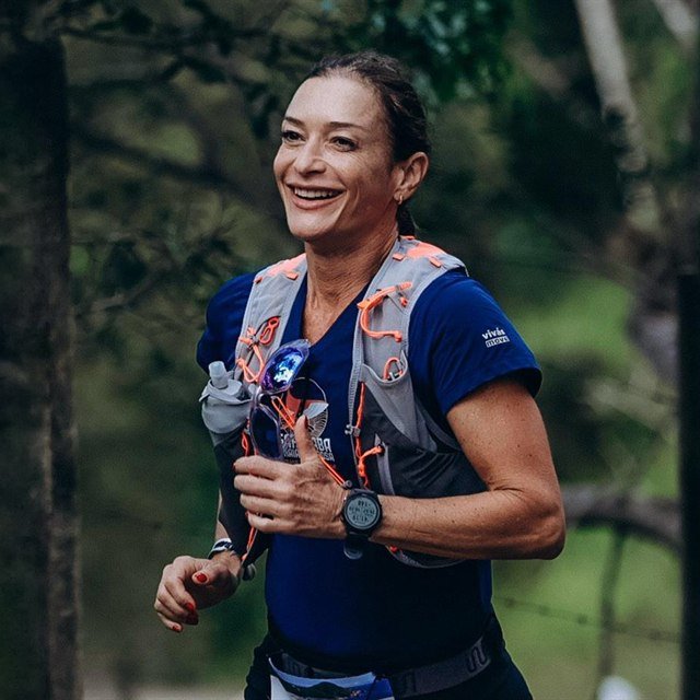 Joice Siqueira, fundadora da AVYVA, correndo em pista de atletismo.